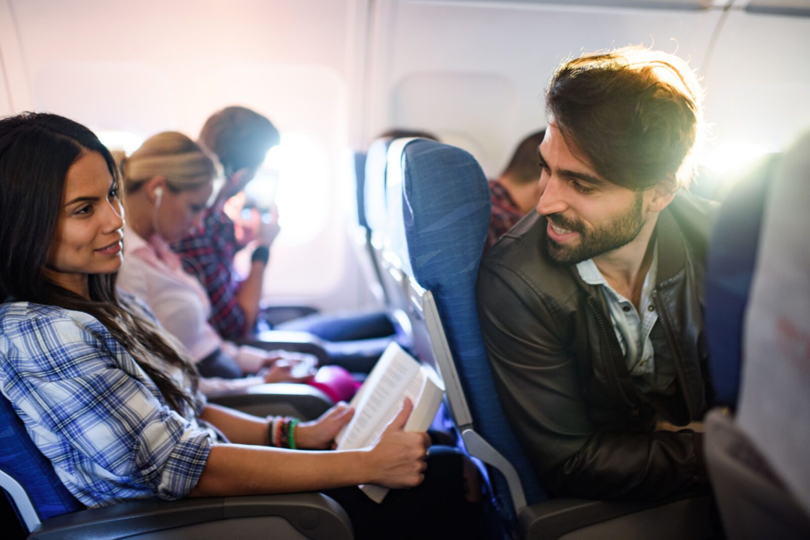 Young passengers talking while traveling by plane.